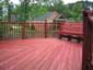 Pressure treated wooden deck with two coats redwood semi-transparent stain